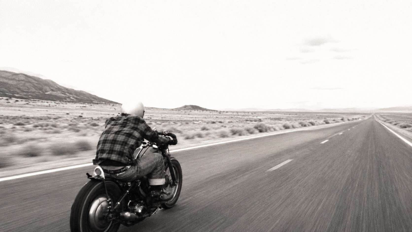 A lone rider heading west on a cold open highway